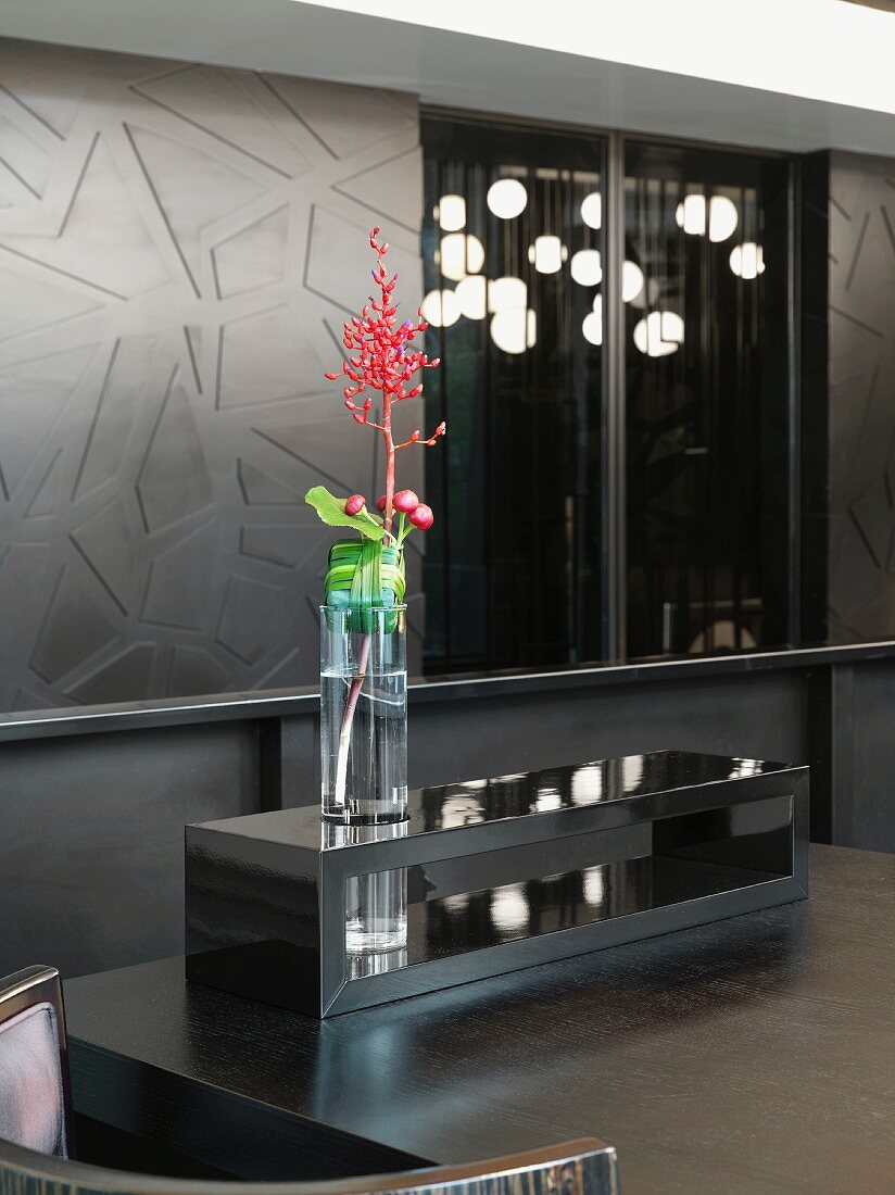 Flower vase on a table made of dark wood with wood paneled walls in a living room