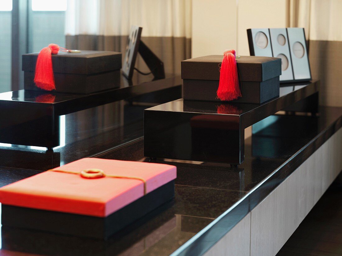 Jewelry boxes on a low counter in front of a mirror