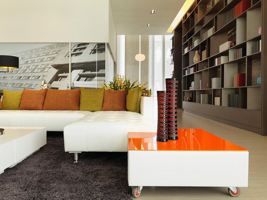 Living room with white sectional sofa with green and orange throw pillows