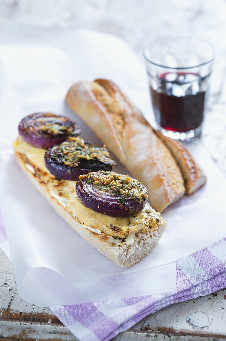 A chicken, mustard and red onion baguette sandwich