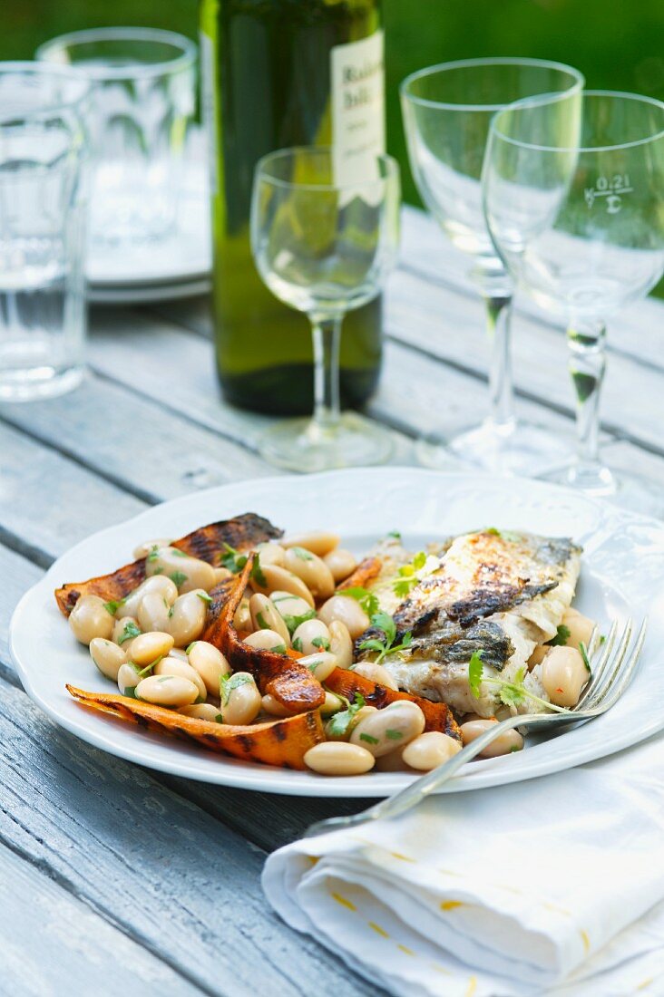 Gegrillter Fisch mit Süsskartoffelscheiben und weissen Bohnen