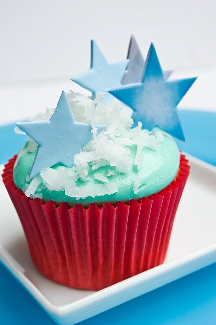 A Christmas cupcake decorated with blue stars