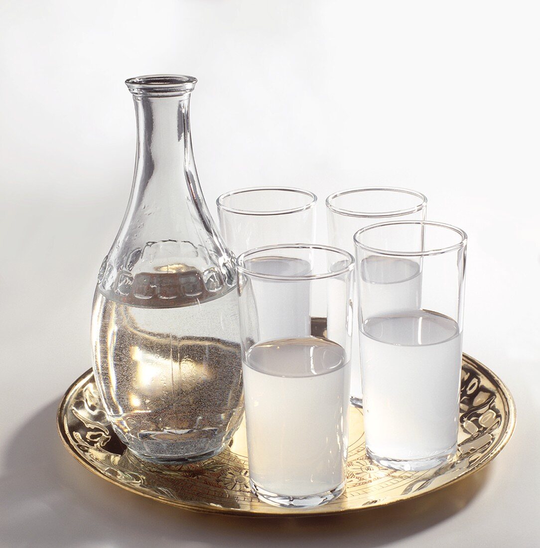 Vier Gläser gefüllt mit Raki & Karaffe mit Wasser