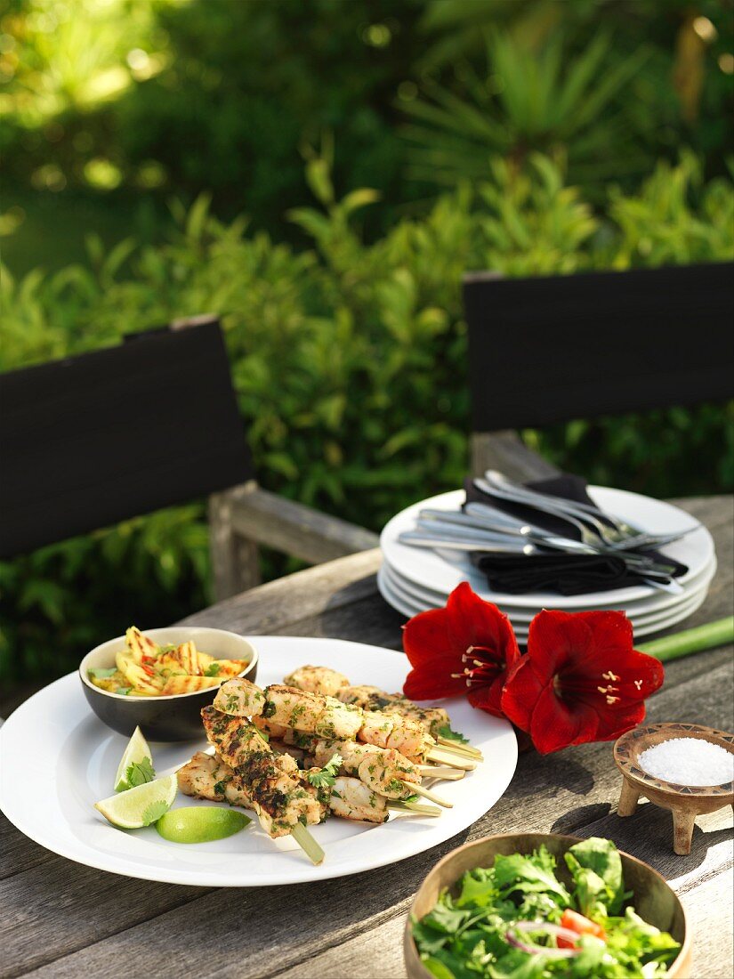 Seafood kebabs with salad on a garden table