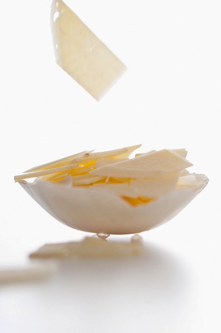 Slices of cheese falling into a bowl