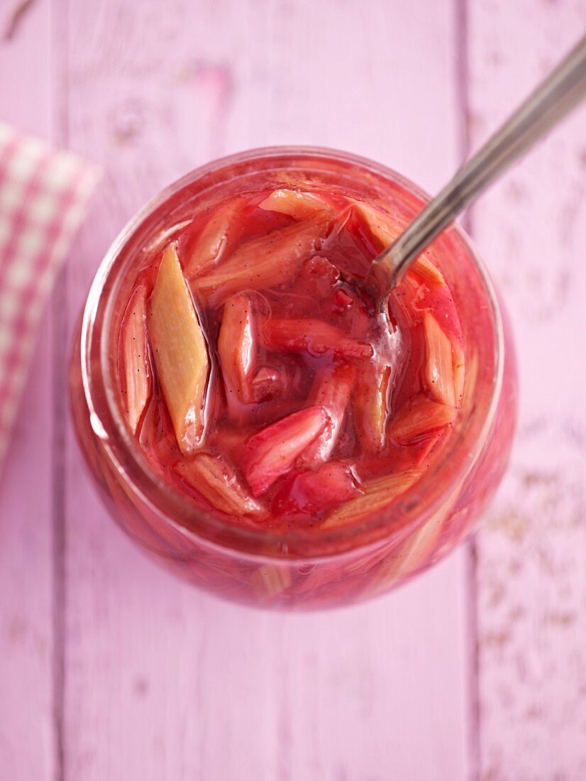 Rhubarb chutney in a preserving jar with a spoon (view from above)