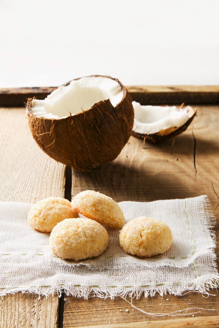 Kokosplätzchen, im Hintergrund aufgebrochene Kokosnuss
