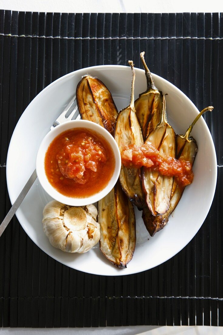 Baked aubergines and garlic with tomato sauce