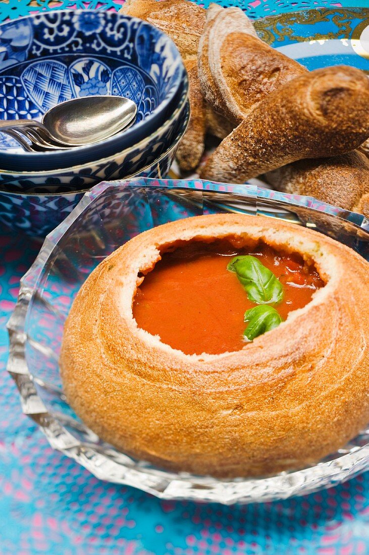 Paprika-Kürbis-Suppe in einem ausgehöhlten Brotlaib serviert