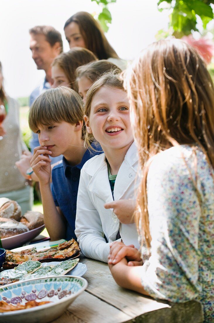 Kinder stehen am Buffet bei einem Gartenfest