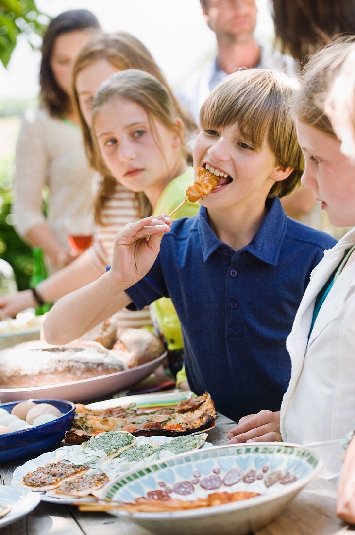 Kinder stehen am Buffet bei einem Gartenfest