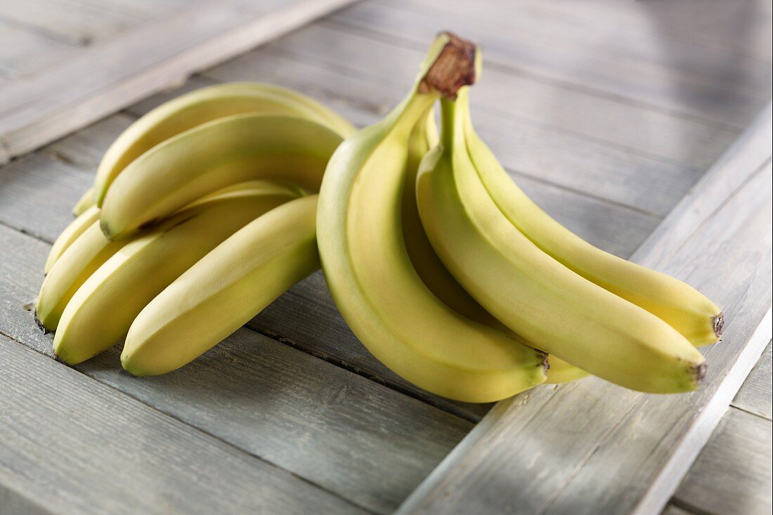 Fresh bananas on a wooden surface