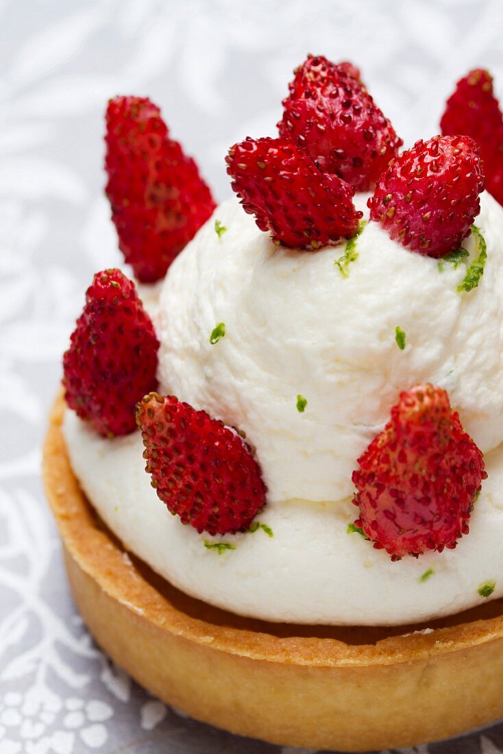 Tartlet topped with lime cream and wild strawberries