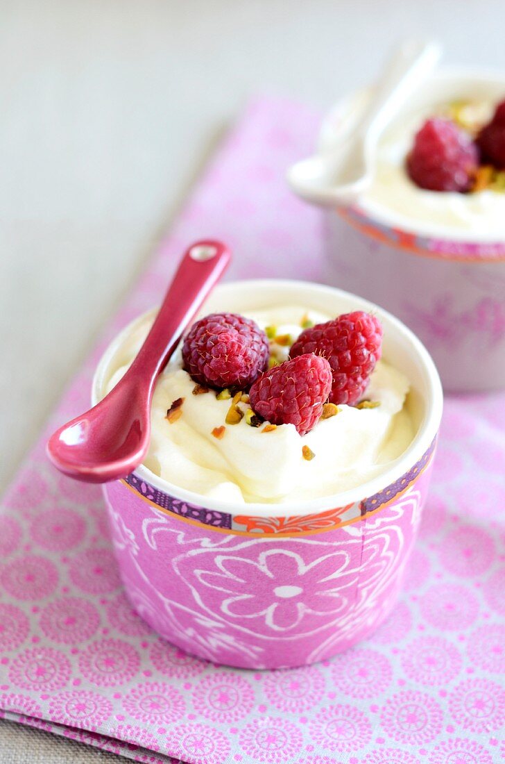 weiße Mousse au chocolat mit frischen Himbeeren und Pistazien