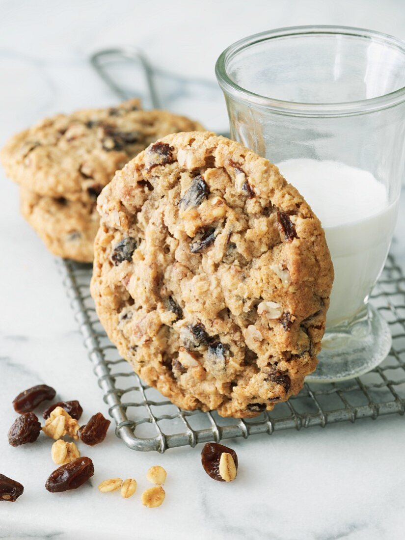 Cookies mit Haferflocken & Rosinen, dahinter ein Glas Milch