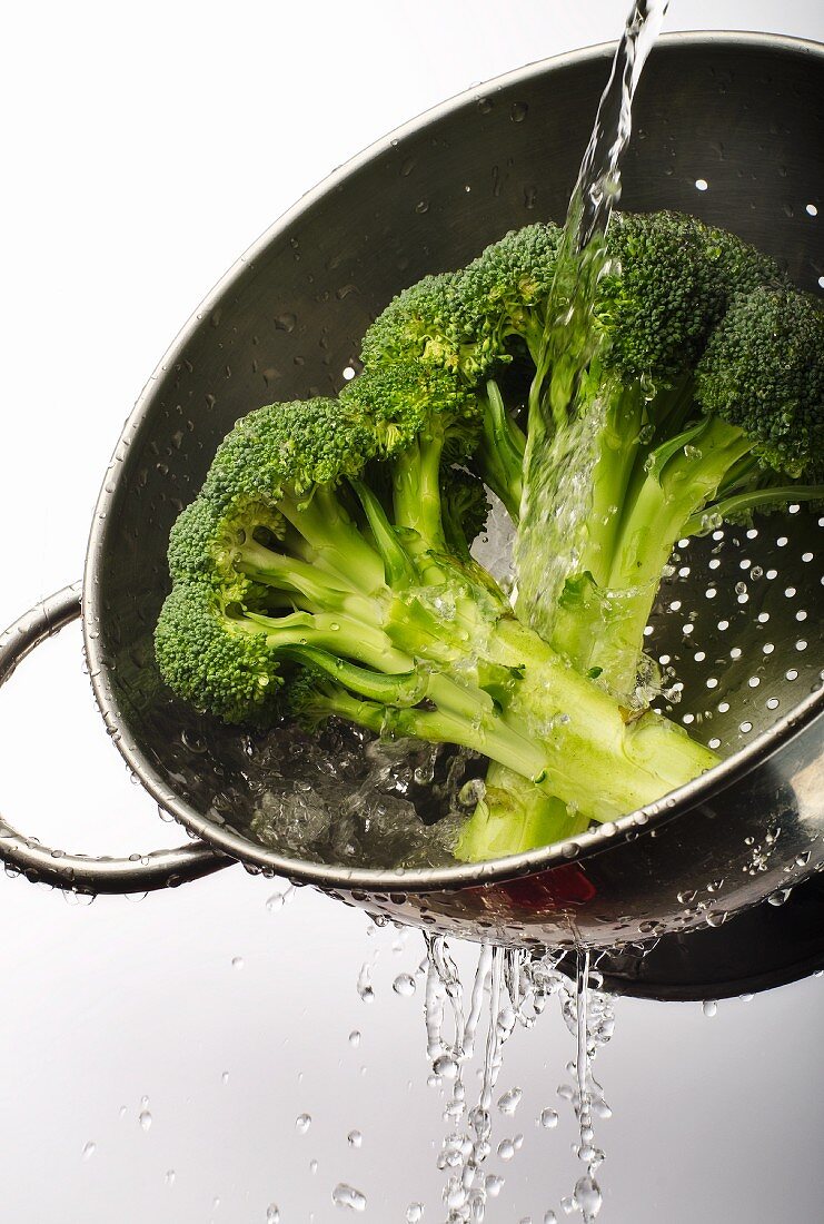Broccoli Being Washed in a Colander