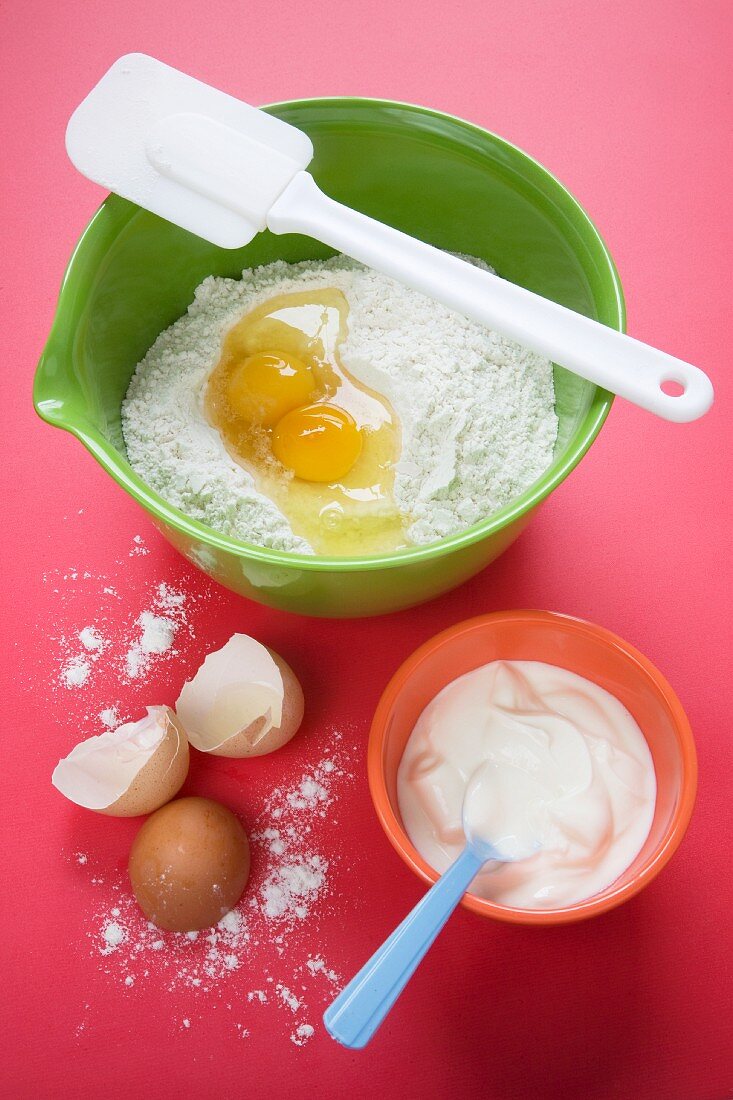 Mehl & Eier in Rührschüssel, daneben Eierschalen & Joghurt