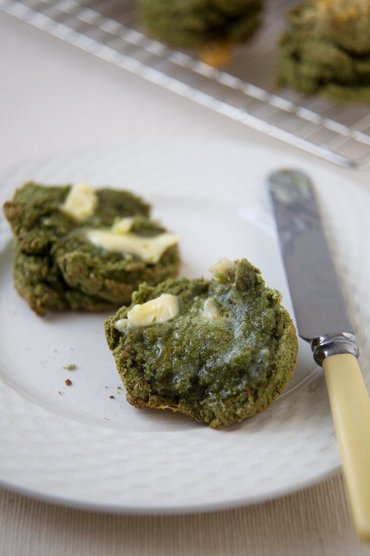 Halbierte Scones aus Gerstengras mit Butter auf Teller