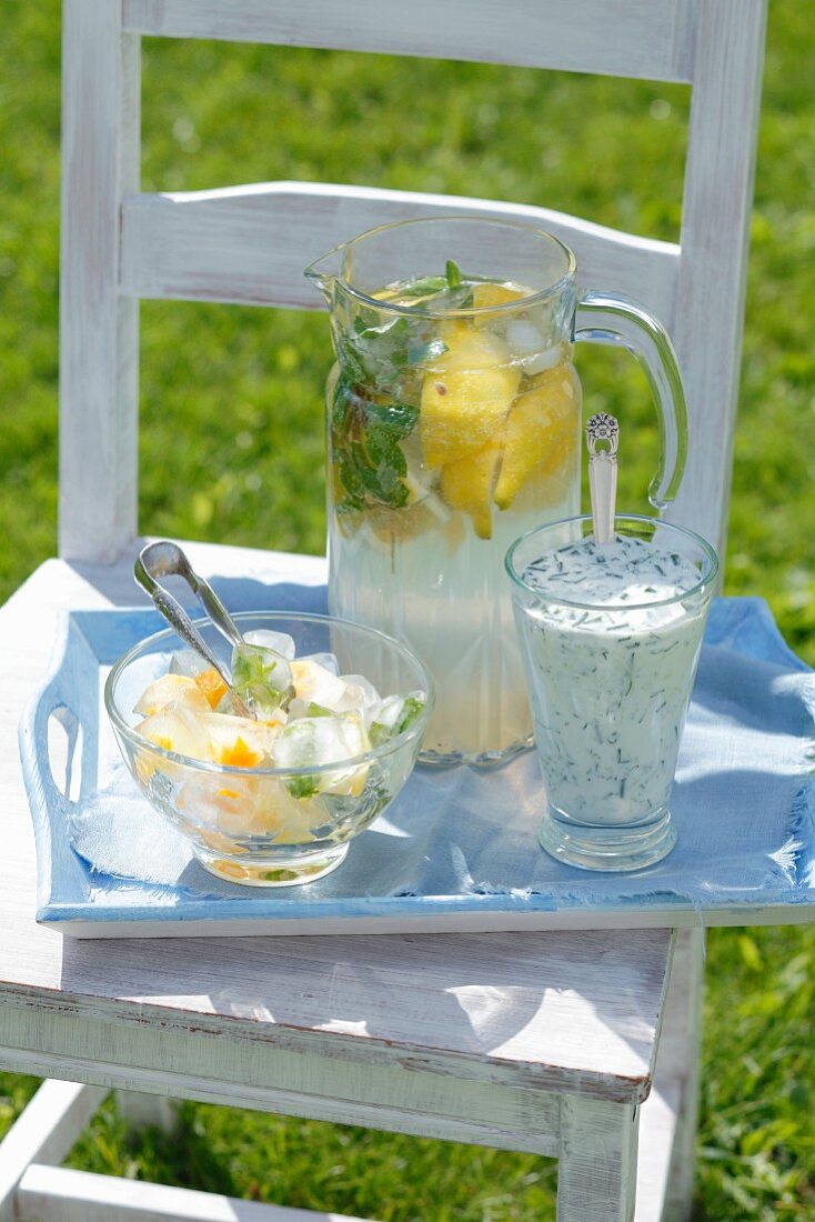Lemonade, a cucumber and dill drink, ice cubes with orange zest and herbs