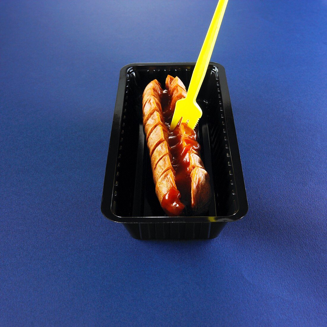 Cervelat (Swiss sausage) with ketchup and a fork