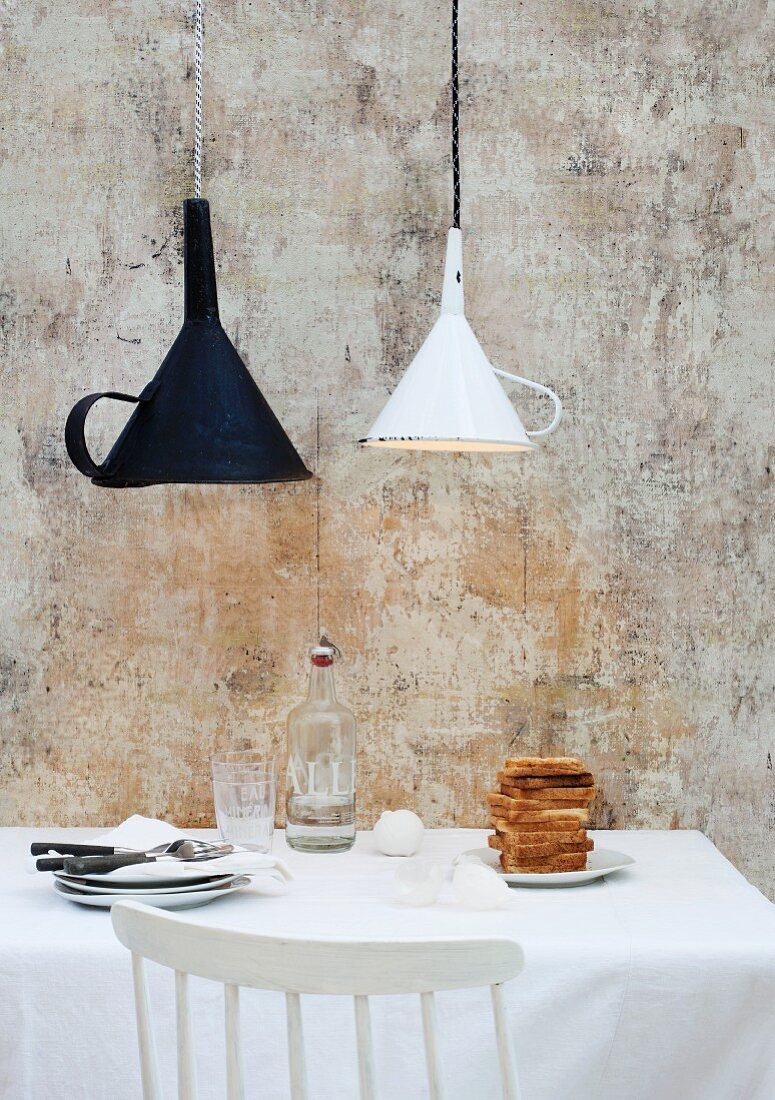 Old kitchen funnels used as unusual lampshades above breakfast table