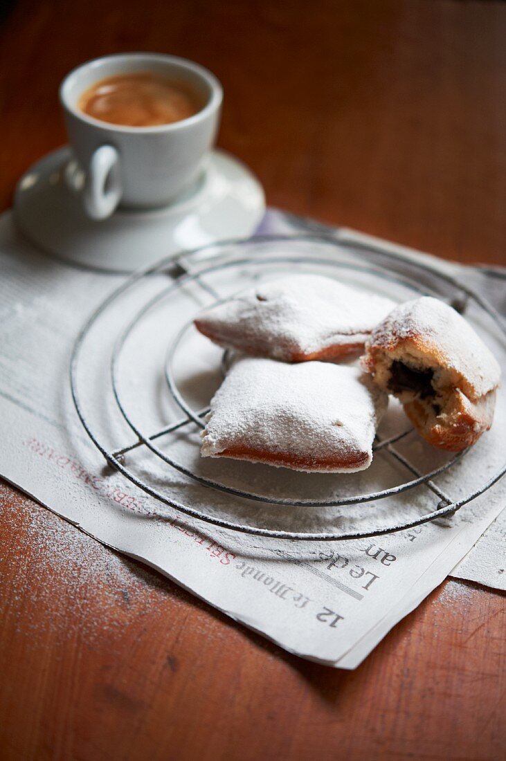 Chocolate Filled Beignets on a Wire Rack Dusted with Powdered Sugar