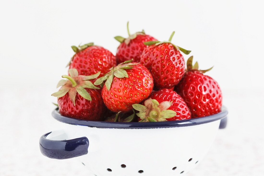 Fresh strawberries in an enamel colander