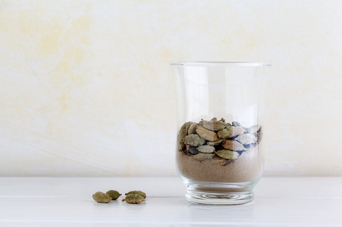 Whole and ground cardamom in a glass