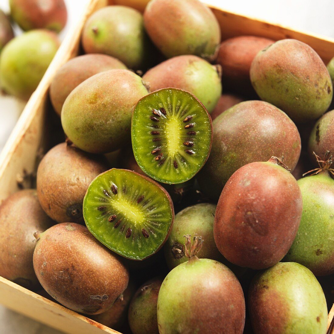 Crate of Fresh Kiwi Berries with One Halved
