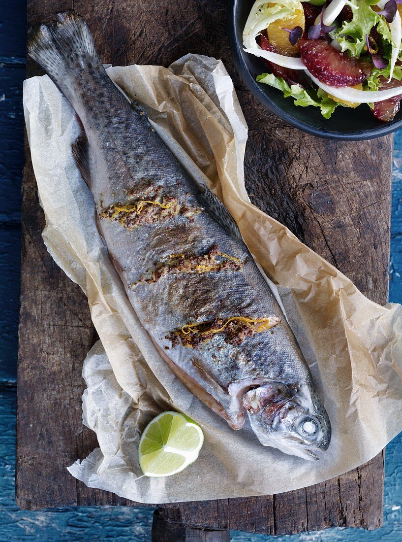 Trout with mustard and orange zest on baking paper