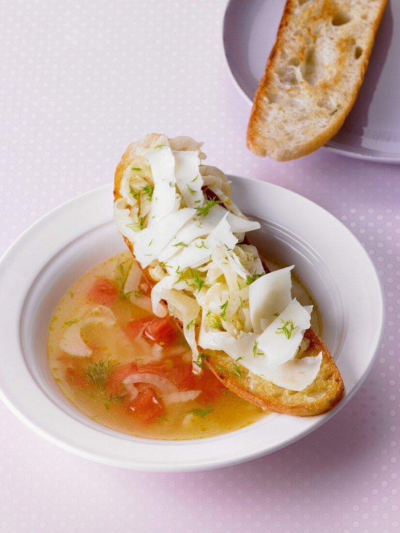 Fennel soup with tomatoes served with crostini topped with fennel and manchego cheese