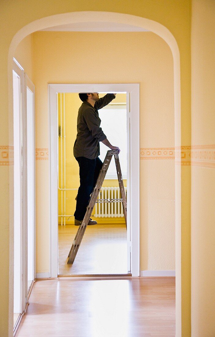 Man changing a light-bulb on a ladder