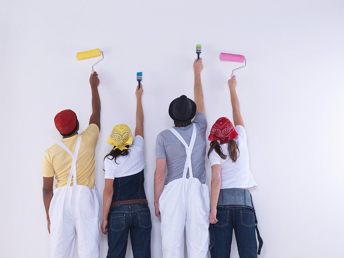 Gruppe von Freunden beginnt eine Wand zu bemalen