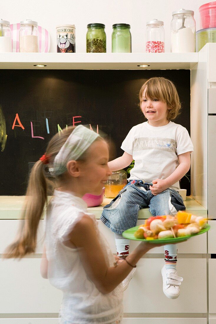 Mädchen und Junge kochen Gemüse