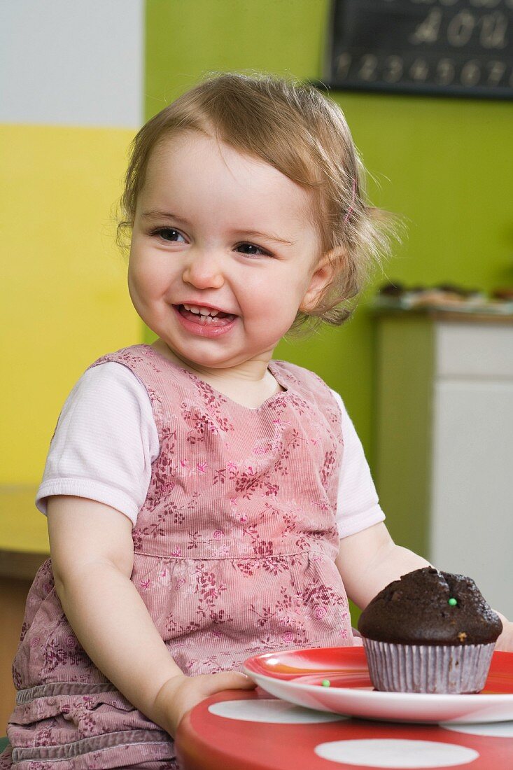 Young girl on table with muffin