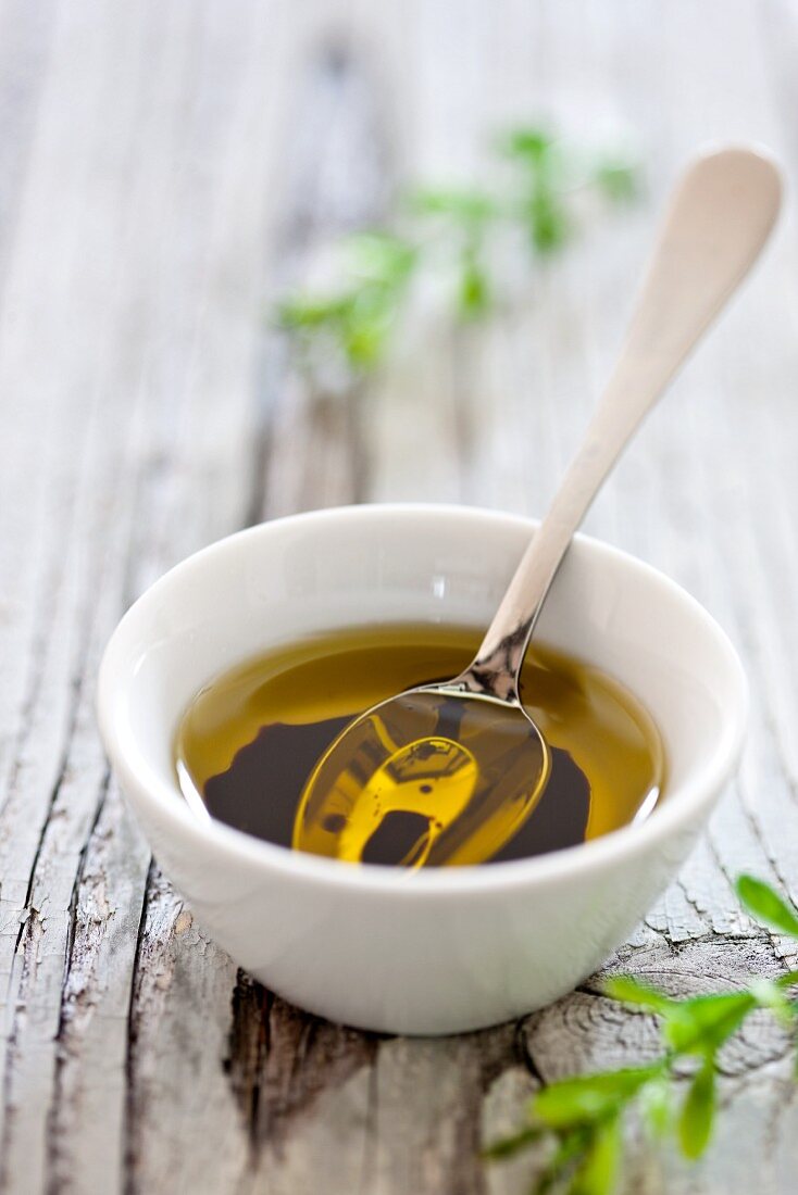 A bowl of olive oil with a spoon