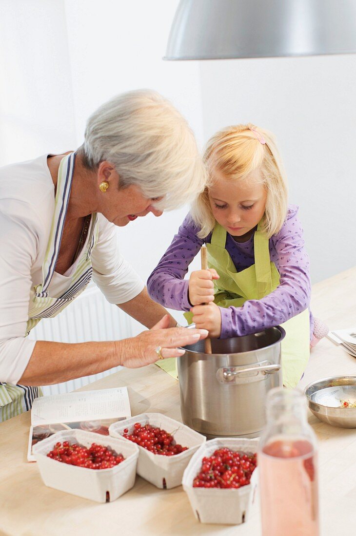 girl with grandmother cooking jam