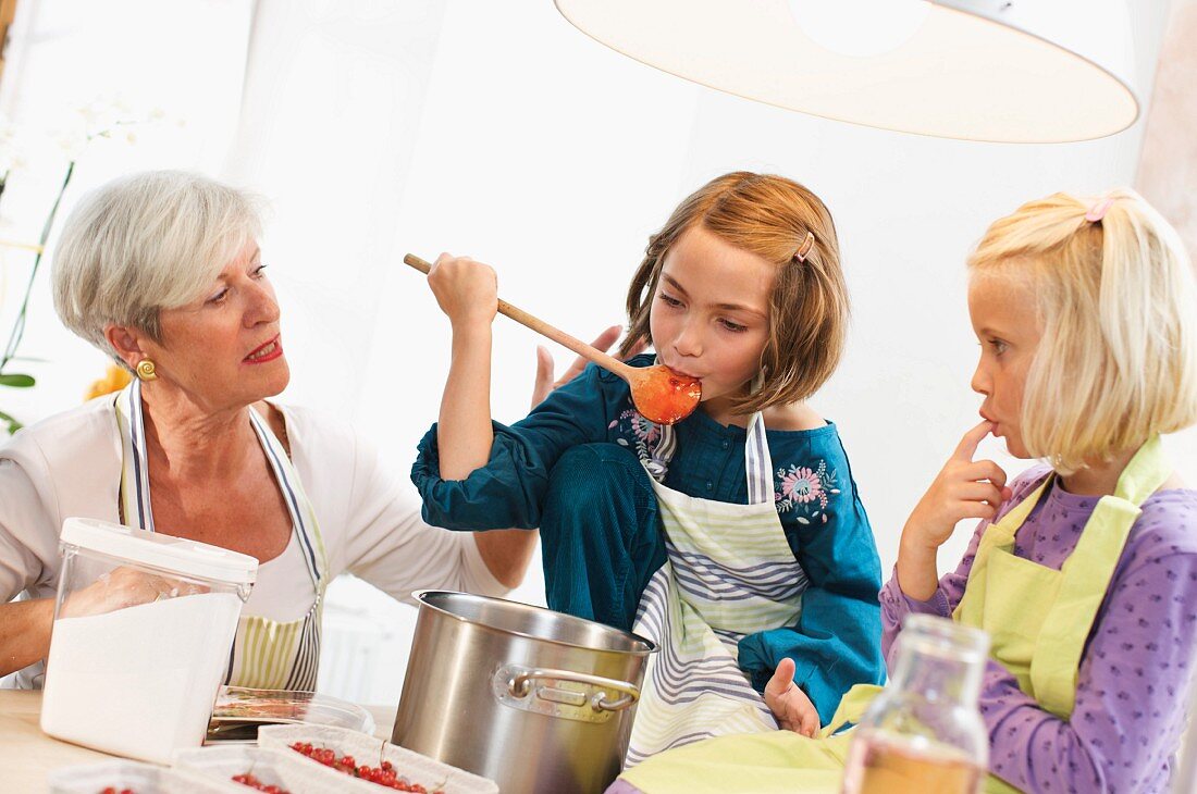 Großmutter und Mädchen kochen Marmelade