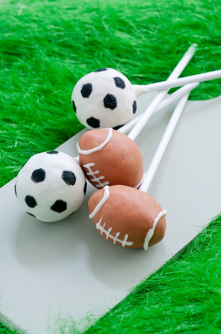 Cake Pops decorated like soccer balls and footballs