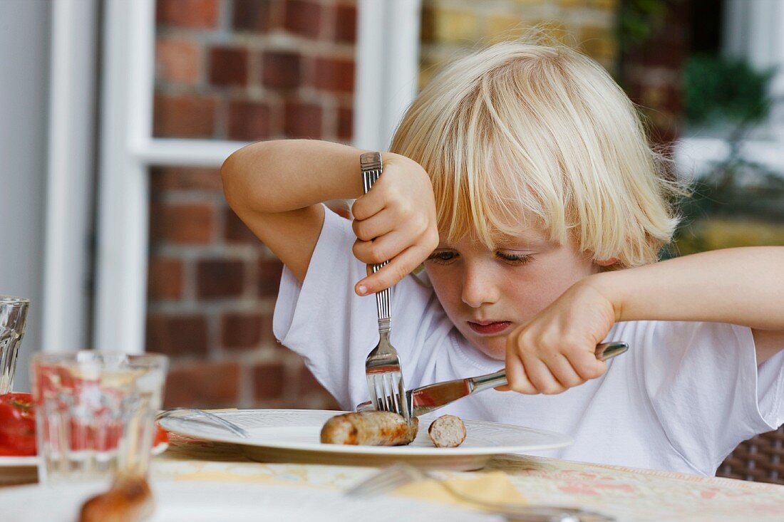 boy eating with knife and fork