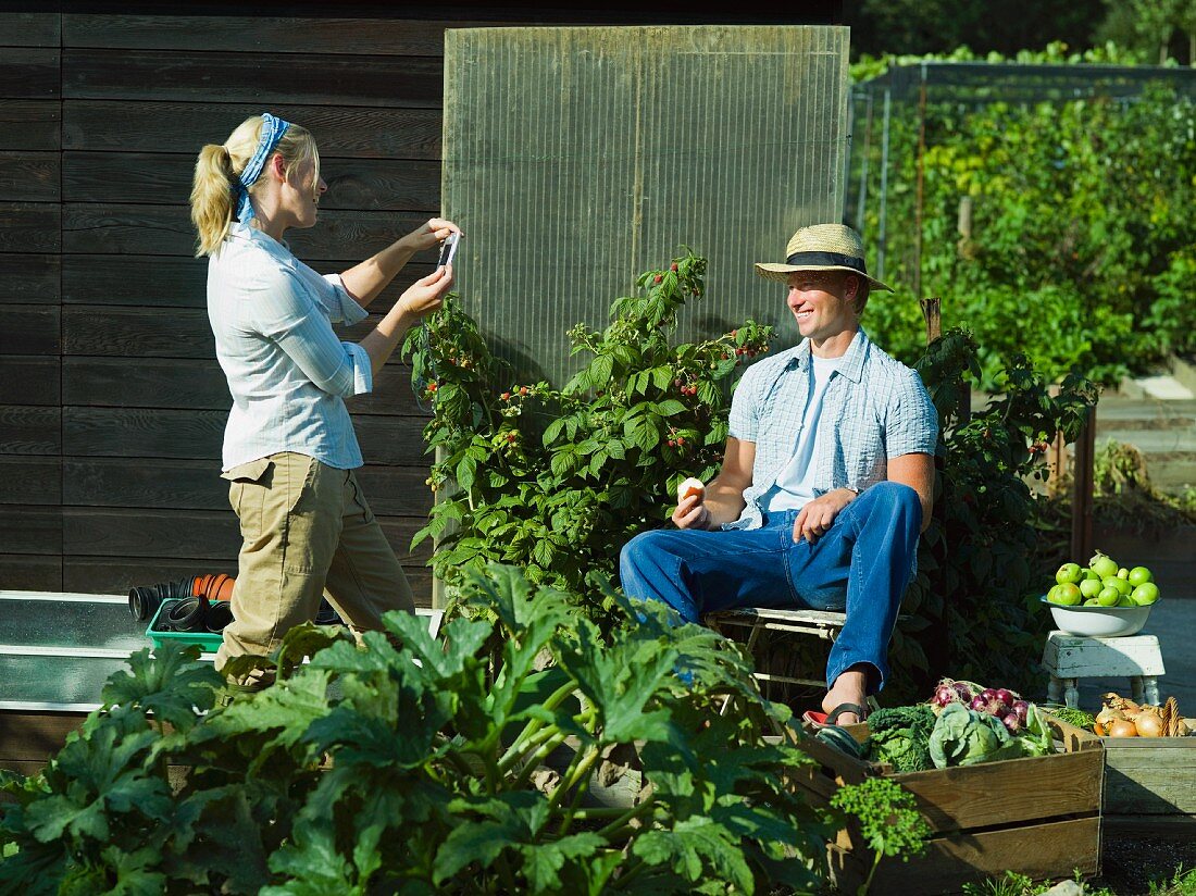 Paar macht Pause bei der Gemüseernte im Garten