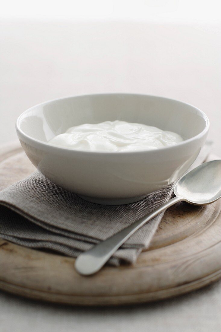 Greek yogurt in a small bowl on a wooden board