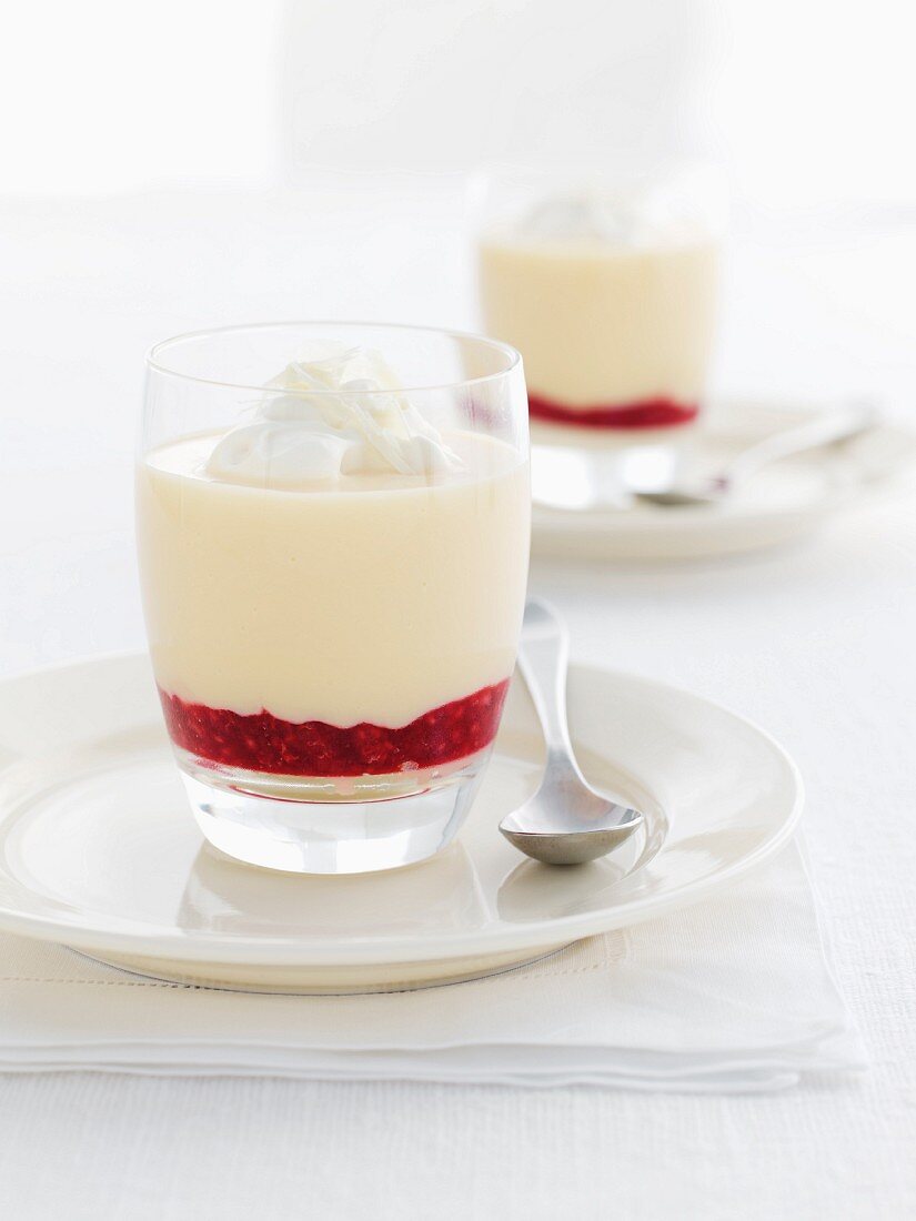 Layered cream dessert with white chocolate and strawberry sauce