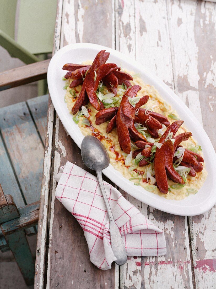 Scrambled eggs with Krainer sausage on a rustic wooden table