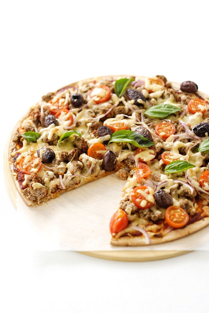 Pizza mit Hackfleisch, Zwiebeln, Oliven & Tomaten, angeschnitten