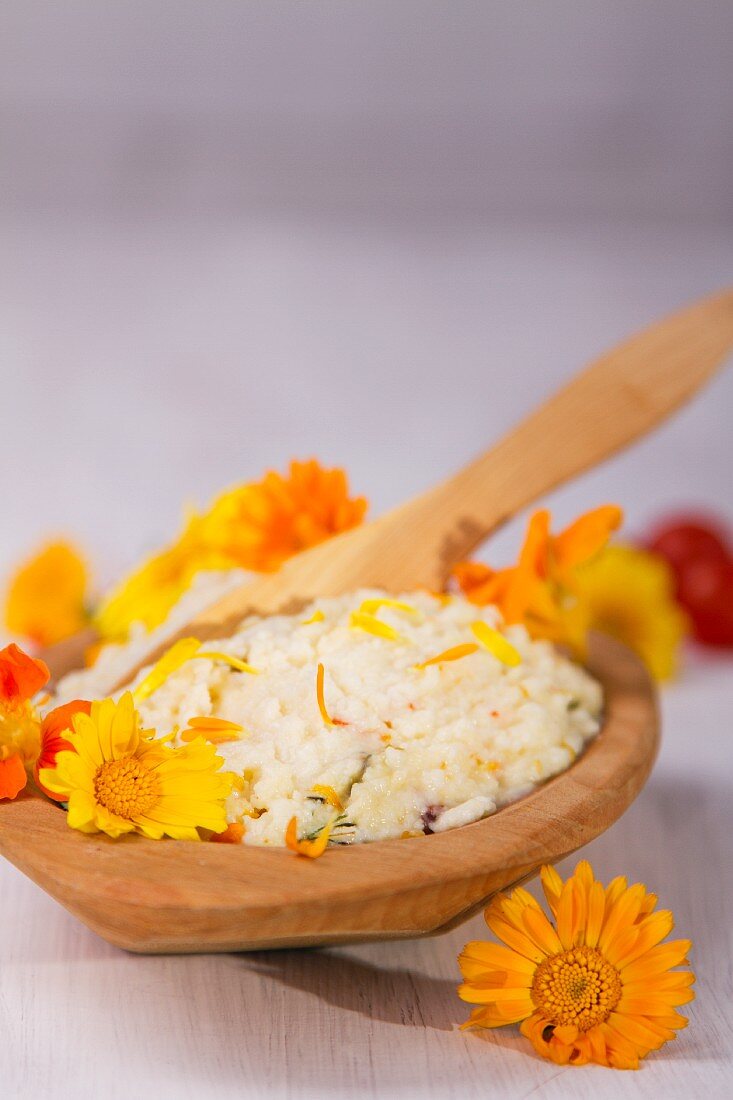 A wooden bowl with rice garnished with marigolds