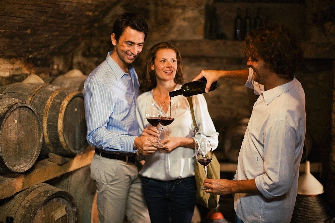 Drei Menschen bei einer Weinprobe