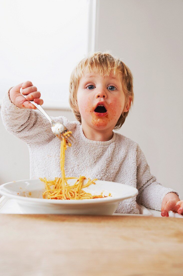 2 year old boy eating spaghetti