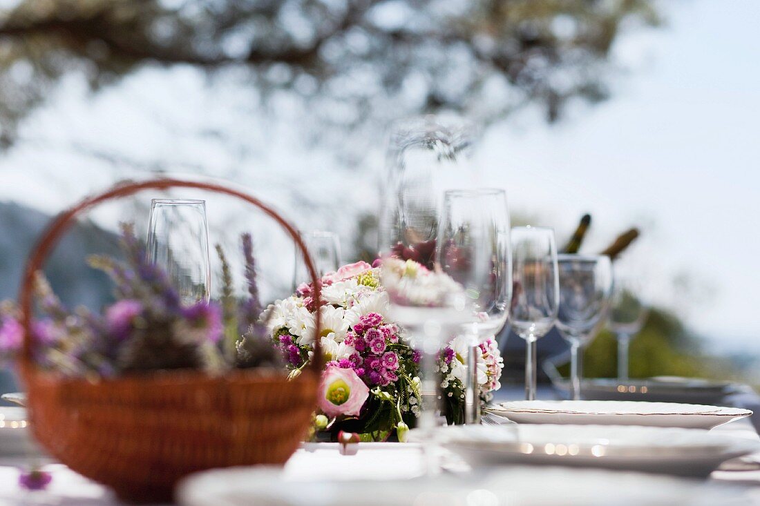 Gedeckter Tisch mit Blumen, Geschirr und Gläsern