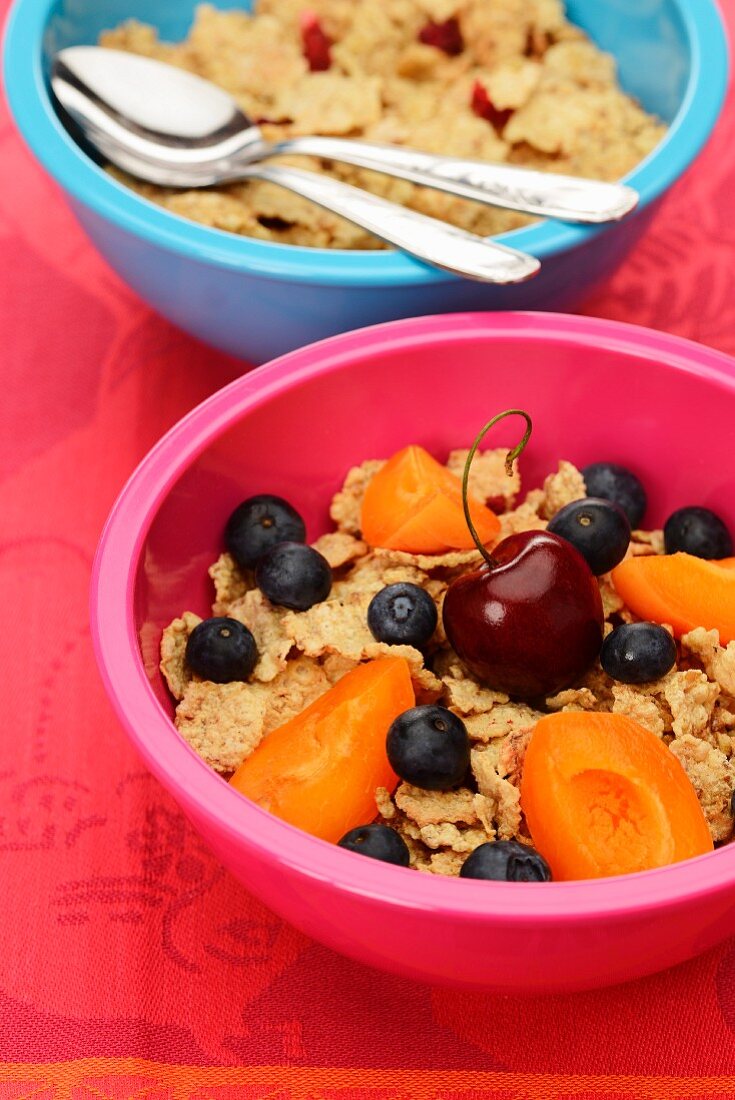 Cornflakes with fresh fruit in colourful bowls